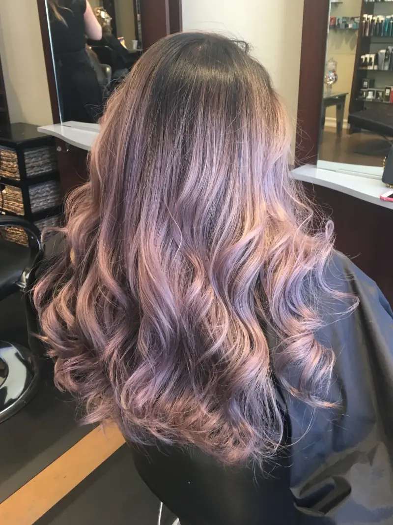 Long wavy hair in smoky lavender and dusty rose with a darker root.