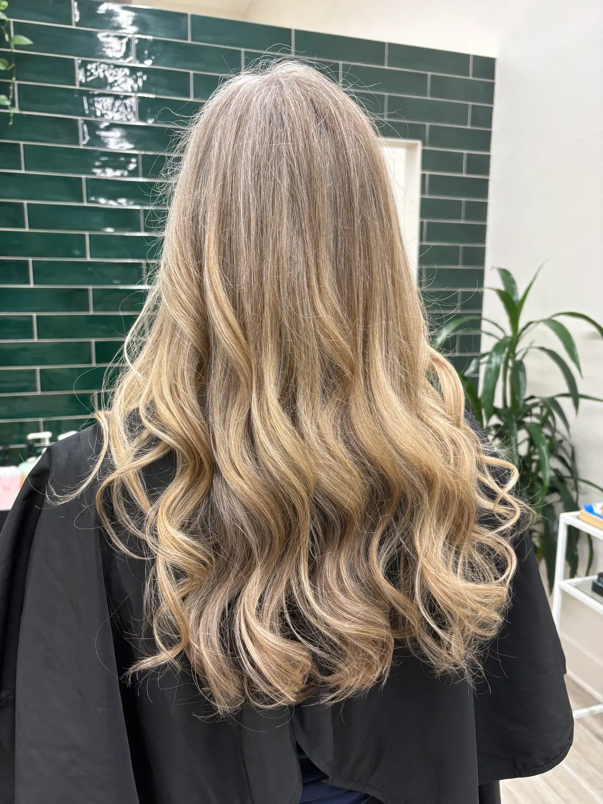 Grey blending on long, wavy hair: natural grey softened with blonde highlights and darker lowlights.